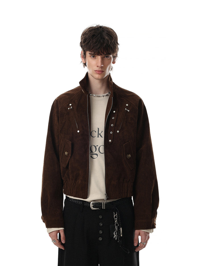 Front view of a brown cropped suede bomber jacket worn with black trousers