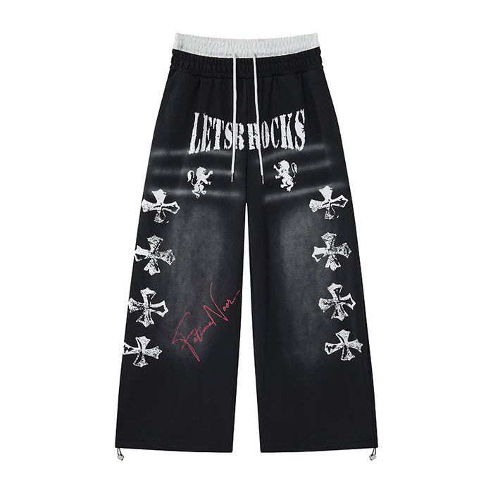 Black wide-leg sweatpants with gray faux waistband, white distressed lettering and cross graphics, red script, and drawcord