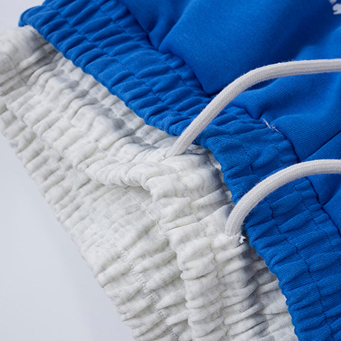 Close-up of blue and gray layered elastic waistbands with white drawcord and gathered stitching