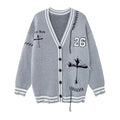 Gray knit cardigan front with striped V-neck trim, black buttons, number 26 patch, cross graphic and distressed details