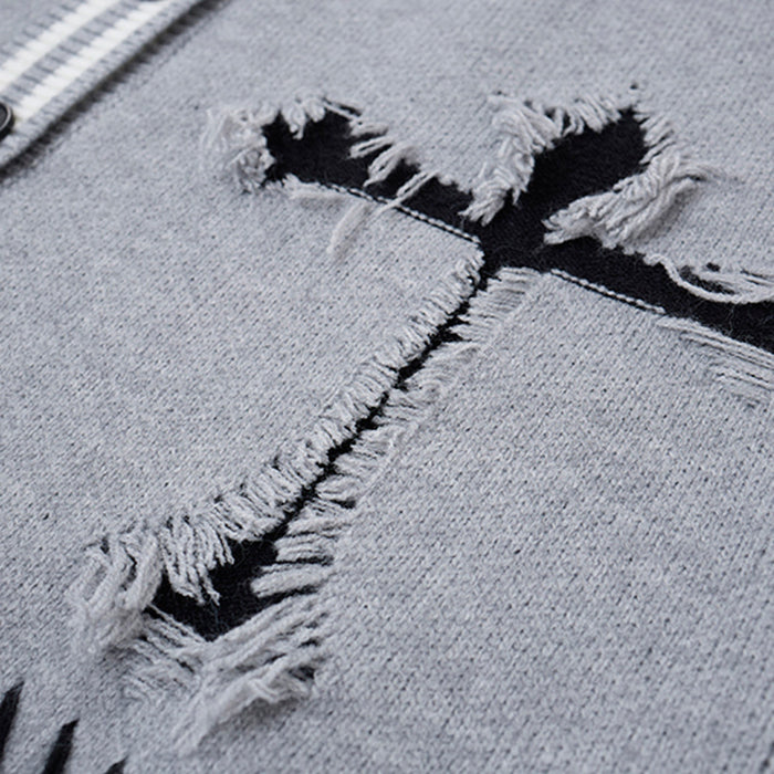Close-up of distressed black cross graphic with frayed gray knit edges on the cardigan front