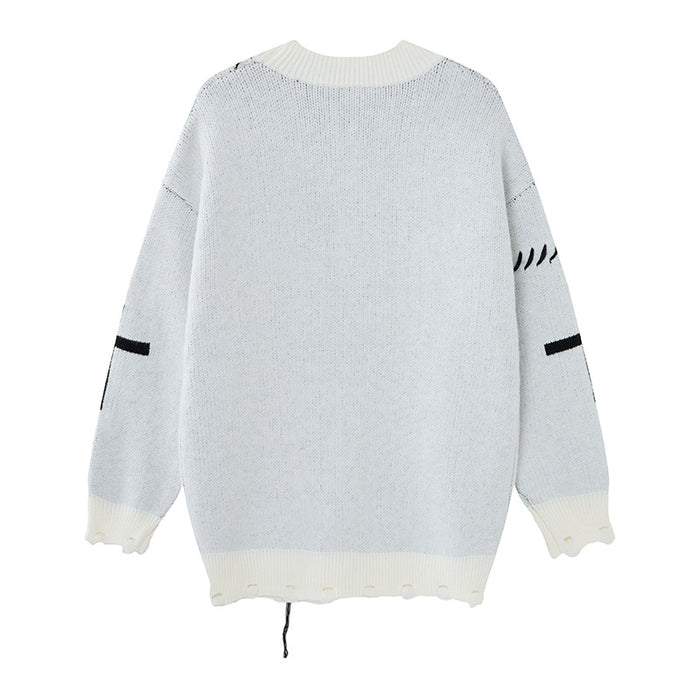 White knit cardigan shown from the back with a plain body, ribbed cream trim, patterned sleeves, and a loose hem thread