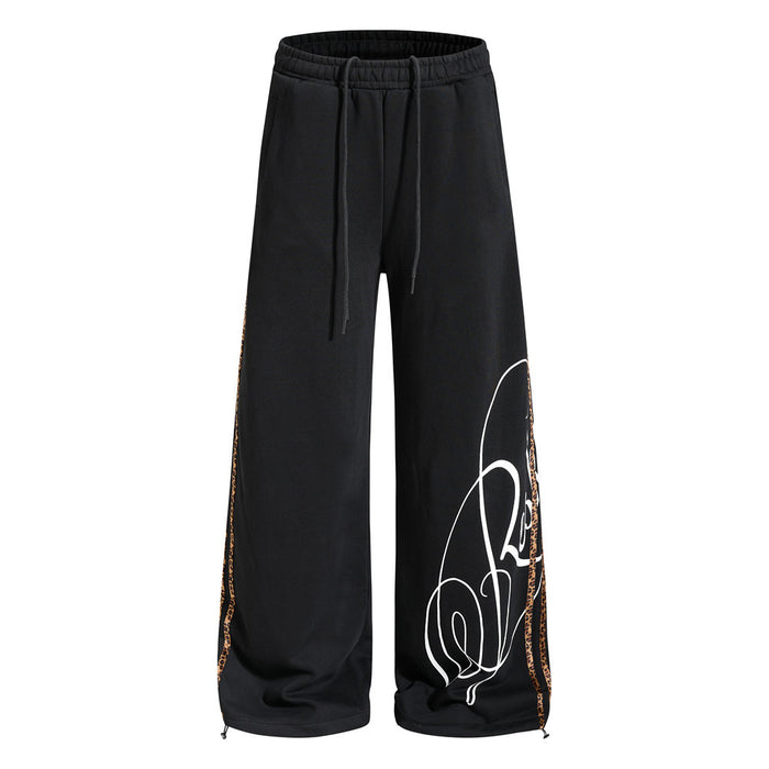 Front view of black wide-leg sweatpants with leopard side tape and white script print