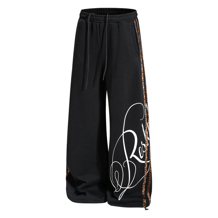 Front angled view of black wide-leg sweatpants with leopard side stripes and script graphic