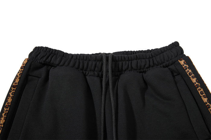 Close-up of elastic waistband with drawstring and leopard trim on black sweatpants