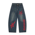 Baggy wide-leg dark wash jeans with red gothic cross and tribal embroidery on front thigh and lower leg