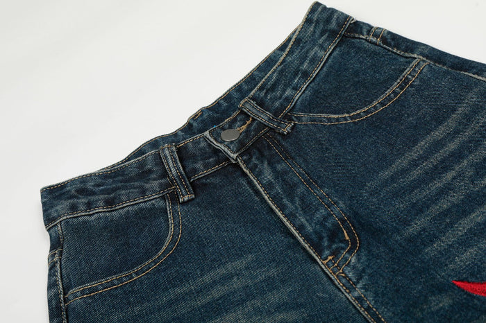 Close-up of dark blue denim waistband, button fly, belt loops, and front pocket stitching