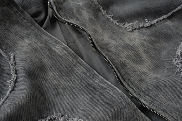 Close-up of the washed gray denim jacket zipper and frayed seam detailing on the front