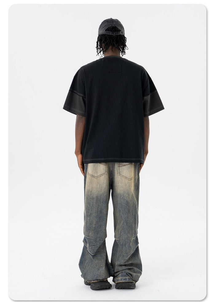 Oversized black patchwork T-shirt worn with distressed wide-leg jeans, back view streetwear outfit
