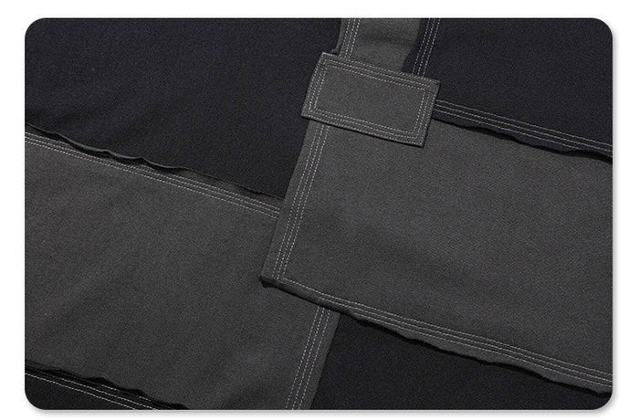 Black oversized T-shirt with deconstructed patchwork panels, contrast stitching, and layered streetwear details