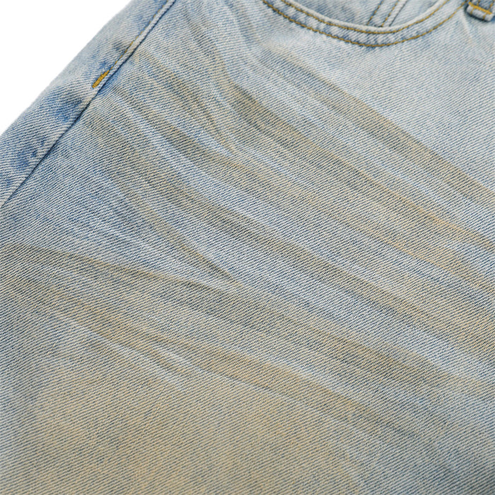 Close-up of light blue denim fabric with faded whiskering and subtle distressing