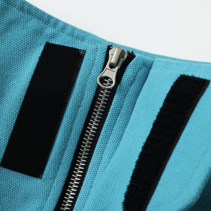 Close-up of front zipper and black trim details on teal bomber jacket collar