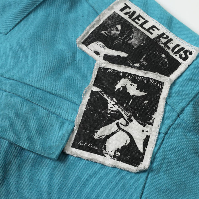 Close-up of two black-and-white graphic patches on teal jacket back