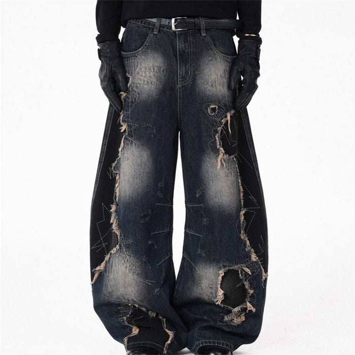 Men's distressed patchwork wide-leg jeans in washed indigo denim with large rips and frayed appliqués