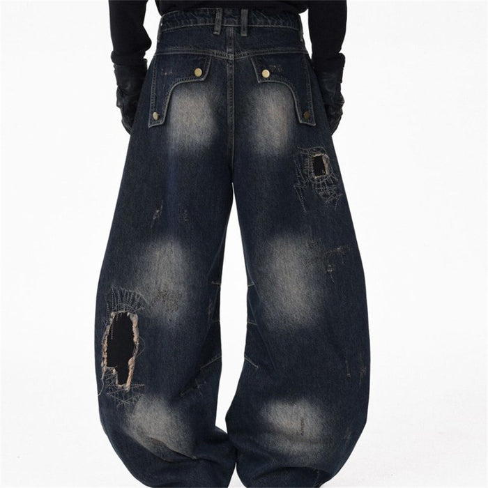 Model wearing the back of dark blue wide-leg jeans with faded seat, flap pockets, and distressed ripped details