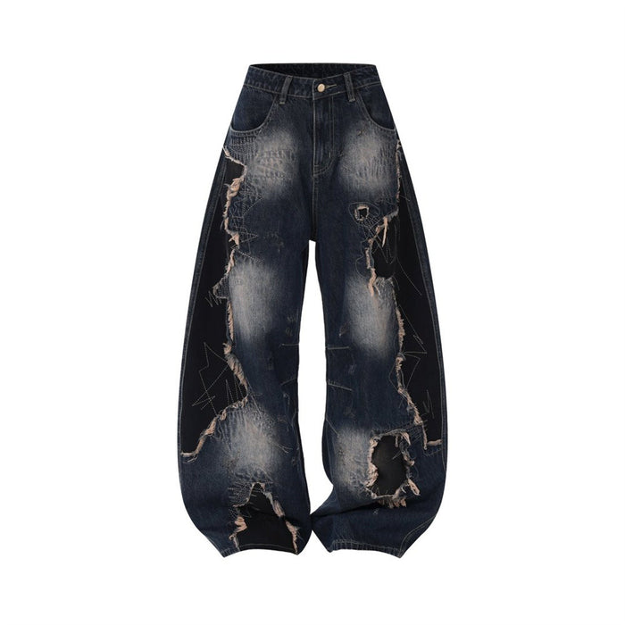 Front view of dark blue wide-leg jeans with washed fading, contrasting patchwork panels, and large frayed rips