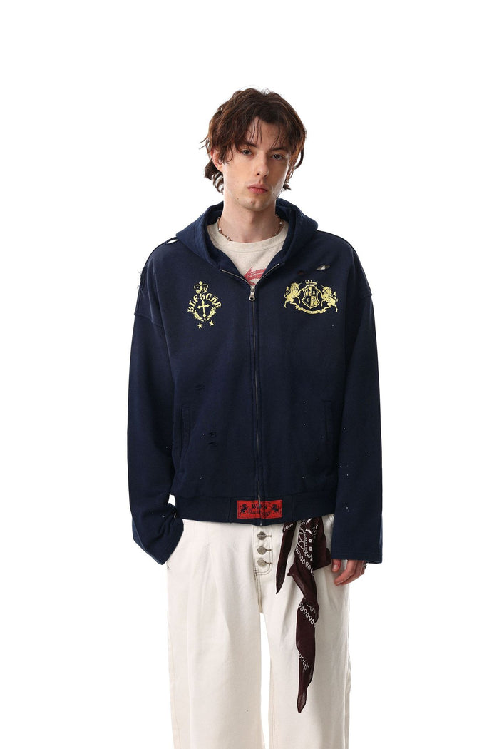 Navy distressed zip-up hoodie worn open at the front with gold crest graphics on the chest