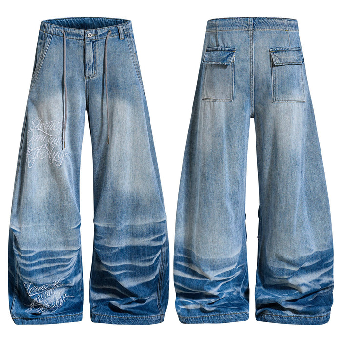 Front and back view of Omirad vintage wash super baggy wide-leg jeans with embroidered script graphics and stacked hem