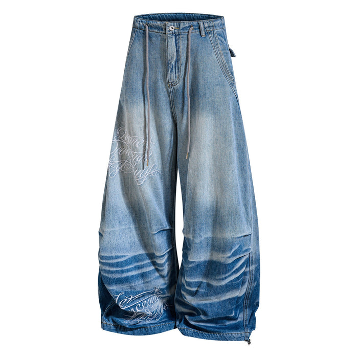 Three-quarter front view of super baggy jeans with drawstring waist and white script leg graphic