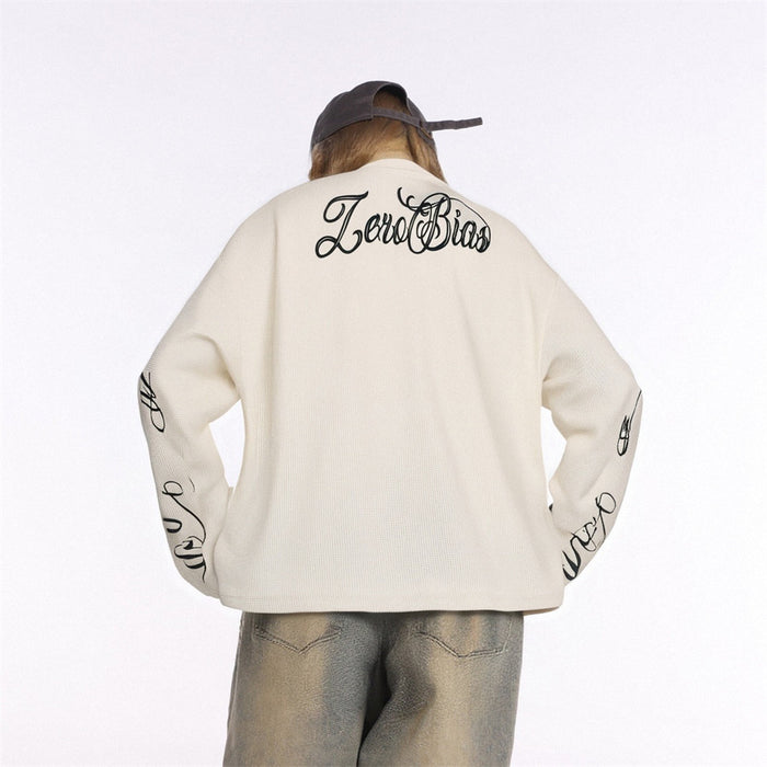 Back view of the cream waffle-knit long sleeve tee with script lettering across the upper back