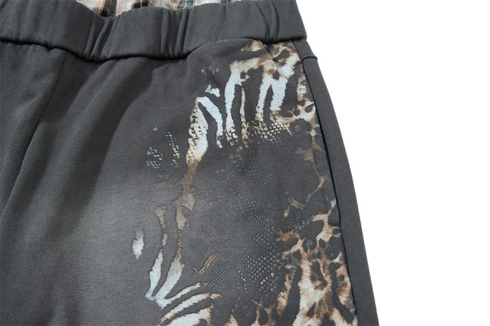 Close-up of leopard print graphic on gray wide leg sweatpants near the hip