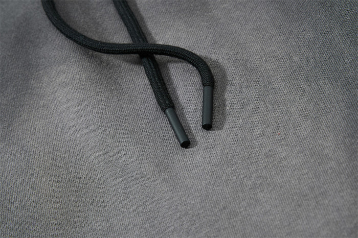 Close-up of black drawstring tips on gray sweatpants fabric