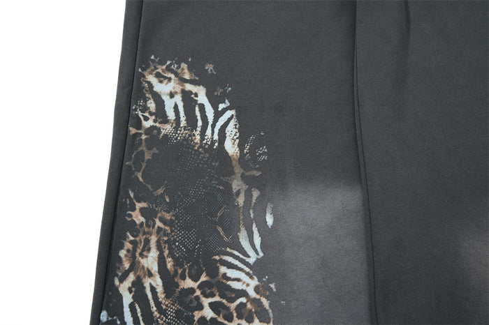 Close-up of leopard and zebra print graphic along the side of gray sweatpants