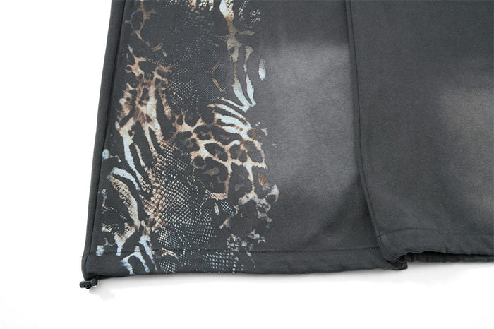 Close-up of lower leg hem on gray sweatpants with leopard print detail
