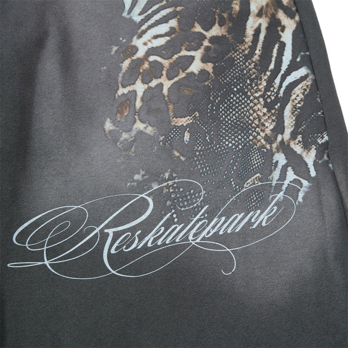 Close-up of leopard print and script graphic on gray sweatpants leg