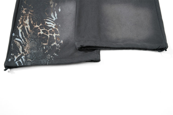Close-up of lower hem and side print on gray wide leg sweatpants