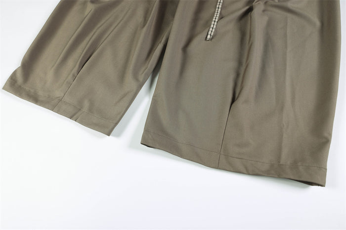Close-up of wide trouser legs and hem on taupe dress pants