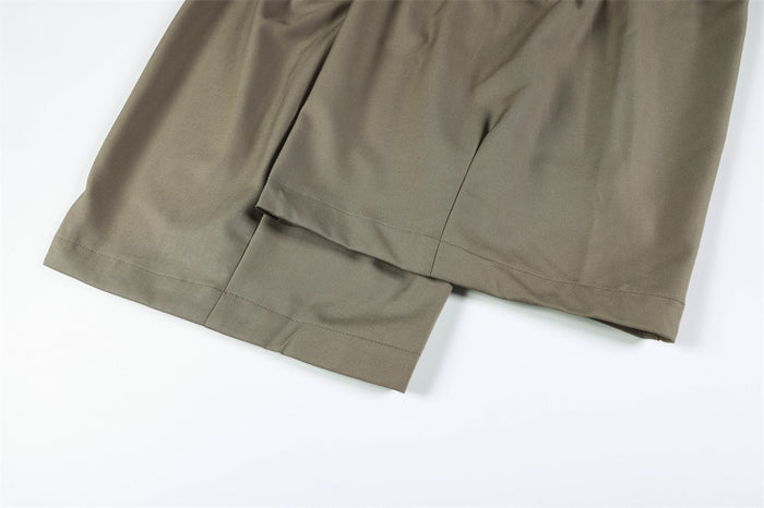 Close-up of overlapping wide trouser hems on taupe pants