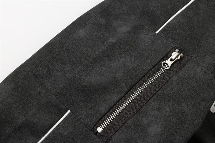 Close-up of black jacket sleeve pocket with zipper and white piping detail