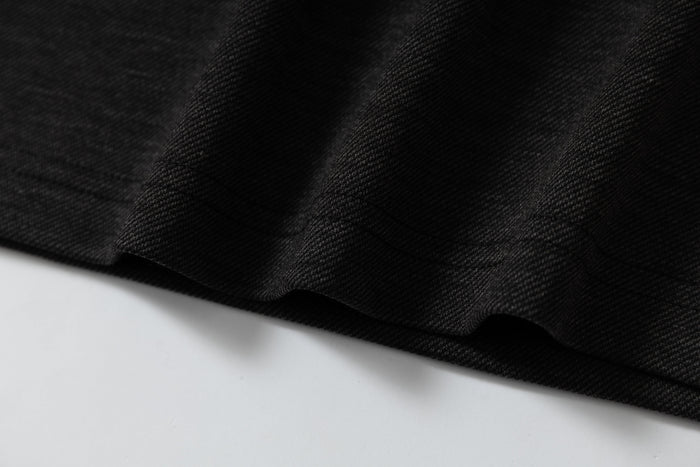 Close-up of black textured fabric on a gothic streetwear raglan t-shirt