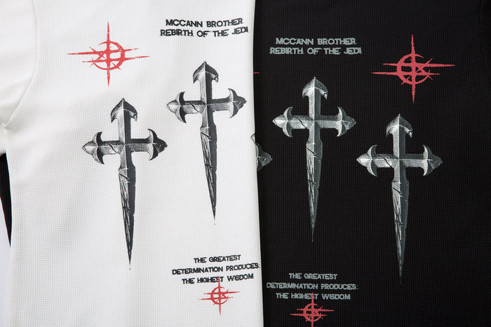 Side-by-side close-up of white and black tees showing cross graphic and printed text