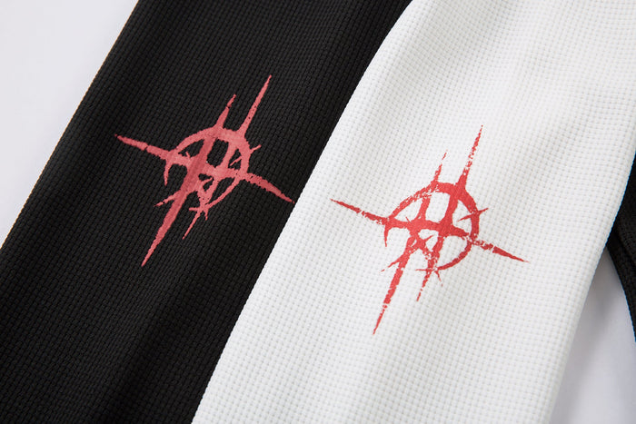 Close-up of sleeve cuffs with red symbol print on black and white fabric