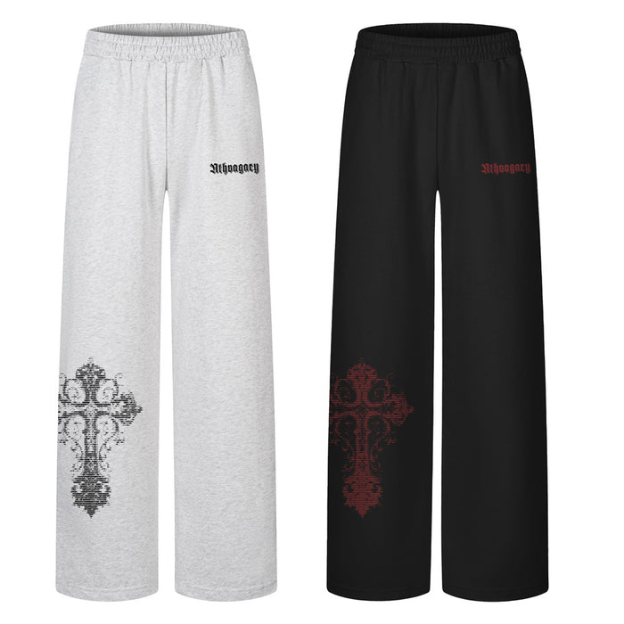 Front view of gray and black wide-leg sweatpants with large cross graphics on the lower legs
