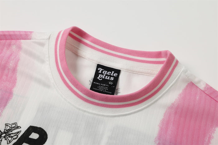 Close-up of pink striped crew neck label on white graffiti print T-shirt