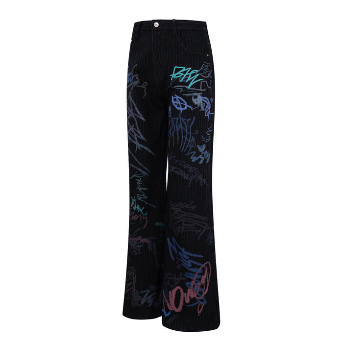 Flat lay angled view of black wide-leg jeans with pinstripes and graffiti print