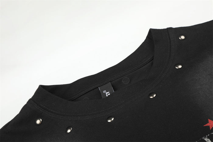 Close-up of black crew neck collar showing ribbed stitching, metal studs, and a partial red star graphic