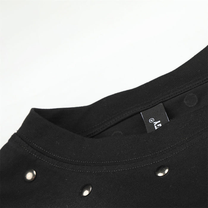 Close-up of black ribbed crew neck with inner label, stitching, and three visible metal studs