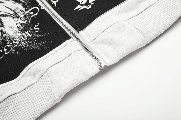 Close-up of the hoodie front zipper meeting the ribbed cropped hem beside the black graphic panel