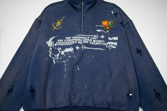 Front view of a navy half-zip sweatshirt featuring a yellow graphic, heraldic chest patch, gothic print, and distressed details