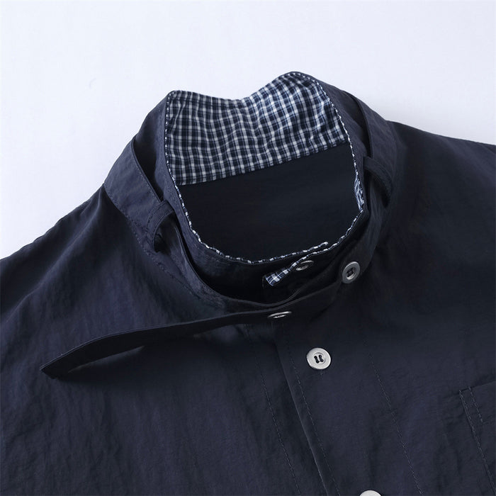 Close-up of high collar with navy plaid inner lining and button closure