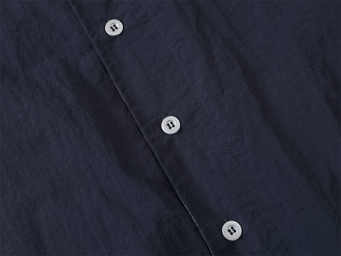Close-up of front button placket on navy overshirt with contrast stitching