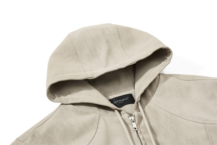 Close-up of the beige jacket hood, drawstrings and silver front zipper at the neckline