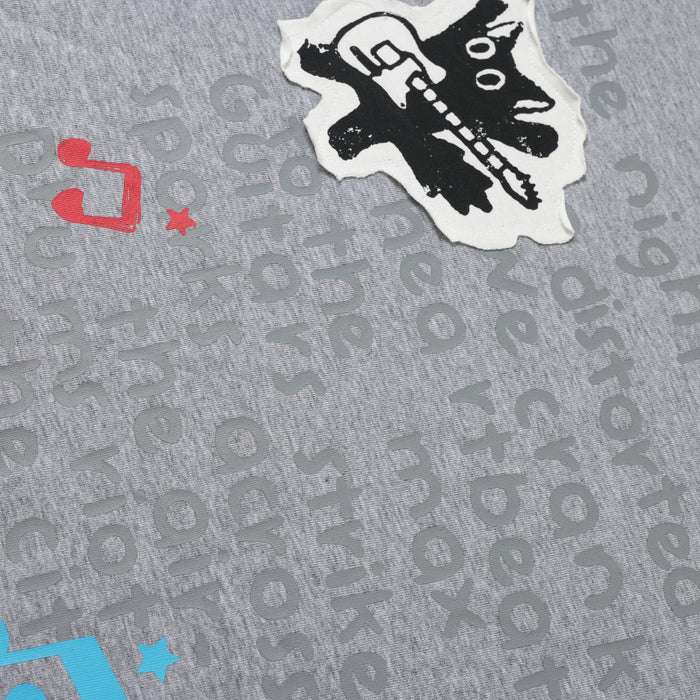 Close-up of gray graphic print with black cat guitar patch and music notes
