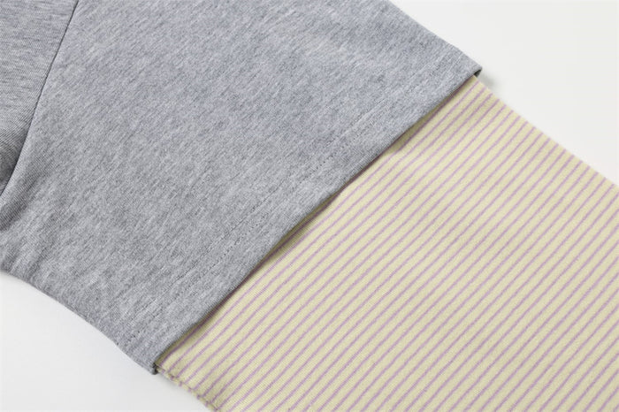 Close-up of gray sleeve with cream thin-striped contrast cuff