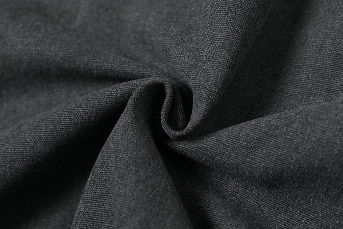 Close-up of black jacket fabric folds showing textured woven material