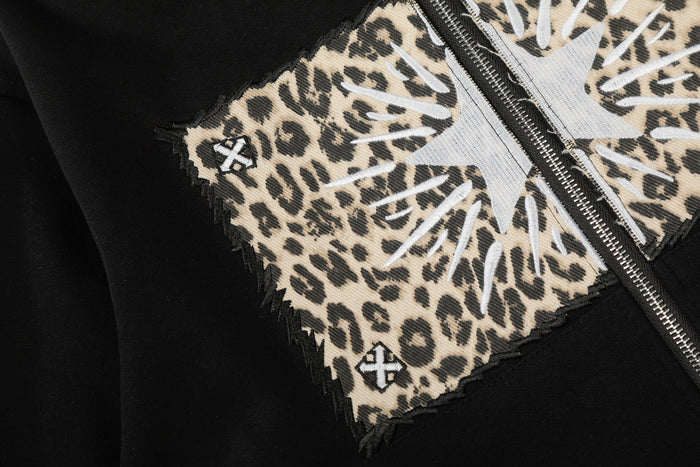 Close-up of leopard panel and white cat graphic on black hoodie